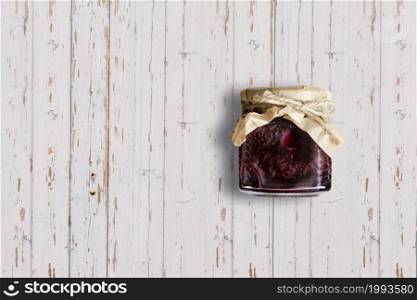 Top up up view Raspberry jam jar isolated on white wooden background. suitable for your design project.