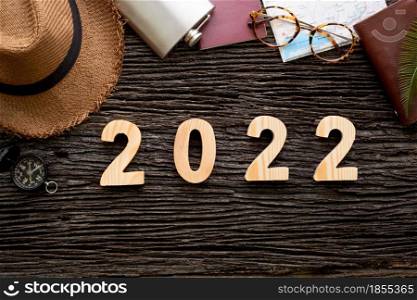 top view 2022 happy new year number on wood table with adventure accessory item,holiday vacation planning