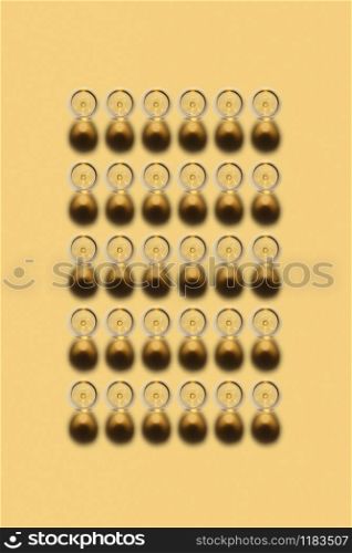 Top view above rectangular alcohol pattern from transparent glasses with white wine on a light yellow background, copy space. Top view.. Rectangular alcohol pattern from glasses of white wine.