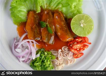 Top view and close up Spicy salad of sardine with tomato sauce in white dish, preparing to cooking food with herb and lemon to persuade a hunger