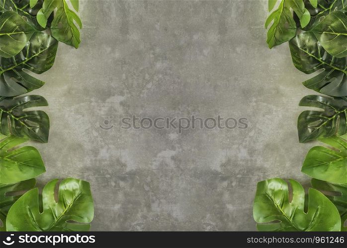 Top view and flat lay of green leaves over cement background. blank sketchbook and green leaves