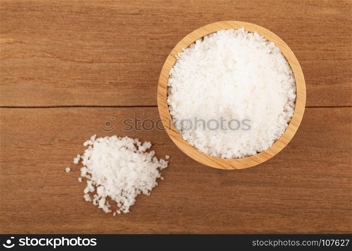 Top view angle of sea salt in wooden bowl on wood background