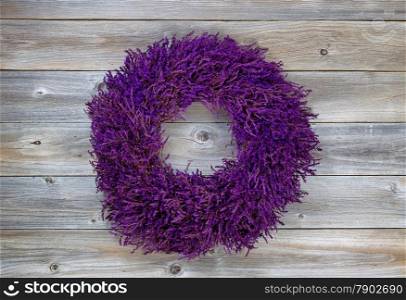 Top view angled shot of seasonal wreath made of lavender on rustic cedar wooden boards.