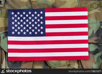 Top view angled shot of United States flag with military uniform background.