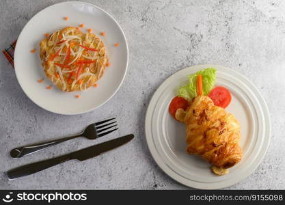 Top view appetizers th Croissant with hotdog and Almond twist bread on white dish decorate with tomato sliced and lettuce beautifully, copy space