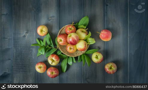 Top view apple on wooden background. Top view red and yellow apple with leaves and bamboo basket on wooden background with free space for text