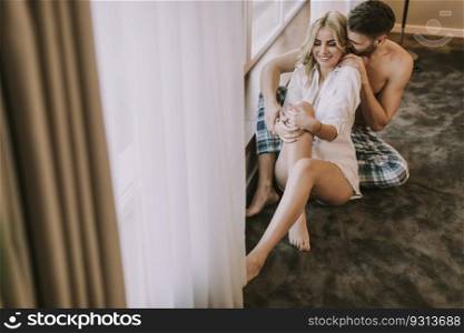 Top view at atracttive loving couple sitting on the floor in the room