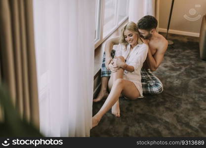 Top view at atracttive loving couple sitting on the floor in the room