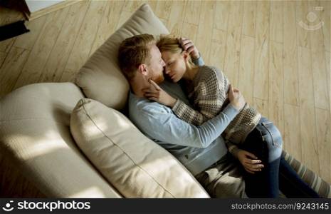 Top view at loving couple lying down on the sofa in the room