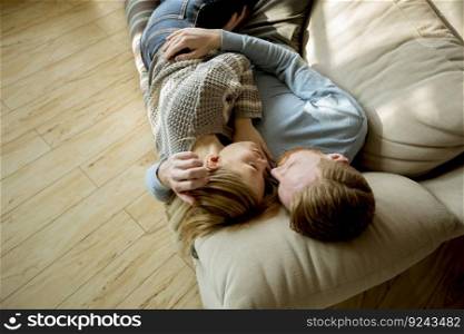 Top view at loving couple lying down on the sofa in the room
