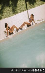 Top view at two young women relaxing by the swimming pool
