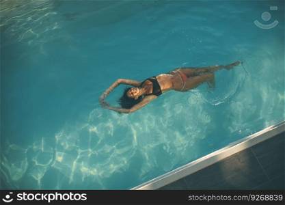 Top view at young woman floating in the pool