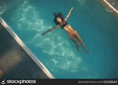 Top view at young woman floating in the pool