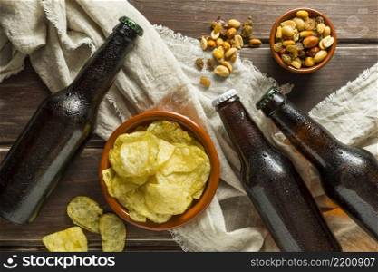 top view beer bottles with chips nuts