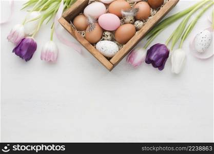 top view box with eggs easter colorful tulips