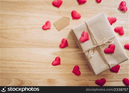 Top view brown gift box and red heart on wood background for valentine day with copy space.