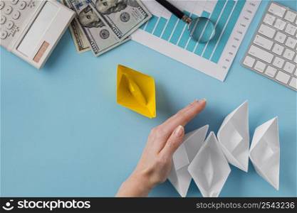 top view business items with growth chart hand keeping paper boats
