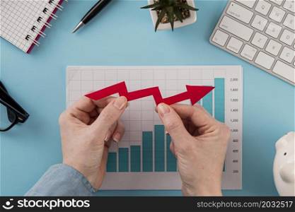 top view business items with growth chart hands holding arrow