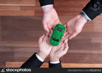 Top view business people exchange and holding green eco car model. Eco-friendly company for environmental friendly transportation. Zero CO2 emission corporate responsible with EV car. Quaint. Business people exchange and holding green eco car model. Quaint