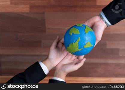 Top view business people holding Earth together in synergy as team building to utilize eco regulation for environmental protection by reducing CO2 emission to save Earth. Quaint. Business people holding Earth together in synergy, Quaint