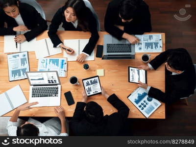 Top-view business team of financial data analysis meeting with business intelligence, report paper and dashboard on laptop for marketing strategy. Business people working together in office of harmony. Business team of financial data analysis meeting report paper in harmony office.