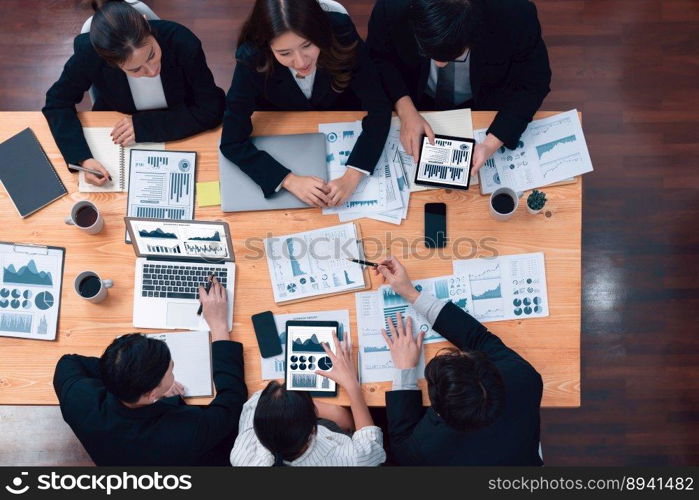 Top-view business team of financial data analysis meeting with business intelligence, report paper and dashboard on laptop for marketing strategy. Business people working together in office of harmony. Business team of financial data analysis meeting report paper in harmony office.