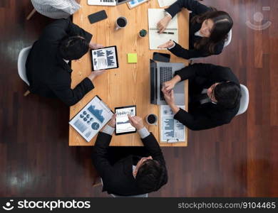 Top-view business team of financial data analysis meeting with business intelligence, report paper and dashboard on laptop for marketing strategy. Business people working together in office of harmony. Business team of financial data analysis meeting report paper in harmony office.