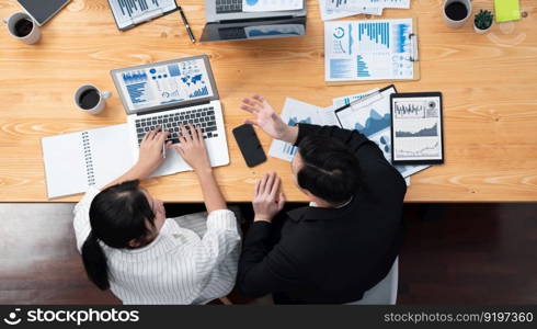 Top-view business team of financial data analysis meeting with business intelligence, report paper and dashboard on laptop for marketing strategy. Business people working together in office of harmony. Business team of financial data analysis meeting report paper in harmony office.