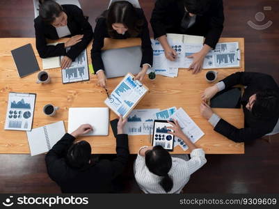 Top-view business team of financial data analysis meeting with business intelligence, report paper and dashboard on laptop for marketing strategy. Business people working together in office of harmony. Business team of financial data analysis meeting report paper in harmony office.