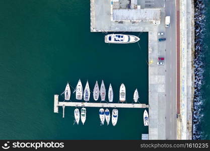 Top View by drone of yachts and small motor boats on the harbor. Yacht and sailboat are moored at the quay. 