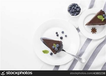 top view chocolate cake slices plates with blueberries