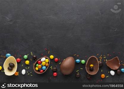 top view chocolate easter eggs filled with colorful candy. High resolution photo. top view chocolate easter eggs filled with colorful candy. High quality photo