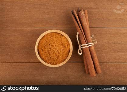 top view cinnamon stick and cinnamon powder on wood background