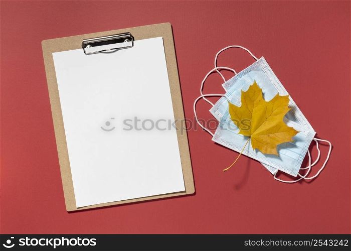top view clipboard with medical masks autumn leaf