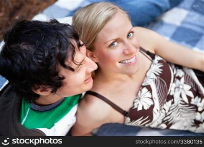 Top view close-up of young man and woman relaxing on picnic blanket