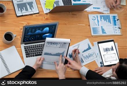 Top-view closeup business team of financial data analysis meeting with business intelligence, report paper and dashboard on laptop. Business group people working together in harmony office.. Business team of financial data analysis meeting report paper in harmony office.