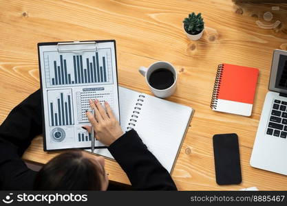 Top-view closeup business team of financial data analysis meeting with business intelligence, report paper and dashboard on laptop. Business group people working together in harmony office.. Business team of financial data analysis meeting report paper in harmony office.