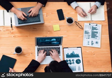 Top-view closeup business team of financial data analysis meeting with business intelligence, report paper and dashboard on laptop. Business group people working together in harmony office.. Business team of financial data analysis meeting report paper in harmony office.