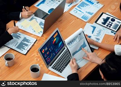 Top-view closeup business team of financial data analysis meeting with business intelligence, report paper and dashboard on laptop. Business group people working together in harmony office.