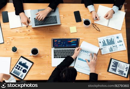 Top-view closeup business team of financial data analysis meeting with business intelligence, report paper and dashboard on laptop. Business group people working together in harmony office.