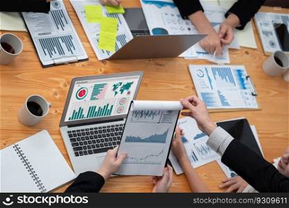 Top-view closeup business team of financial data analysis meeting with business intelligence, report paper and dashboard on laptop. Business group people working together in harmony office.. Business team of financial data analysis meeting report paper in harmony office.