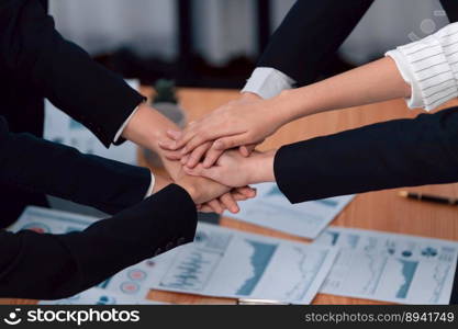 Top view closeup business team of suit-clad businesspeople join hand stack together. Colleague collaborate and work together to promote harmony and teamwork concept in office workplace.. Top view closeup business team join hand stack together for harmony concept.