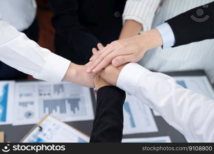 Top view closeup business team of suit-clad businesspeople join hand stack together. Colleague collaborate and work together to promote harmony and teamwork concept in office workplace.. Top view closeup business team join hand stack together for harmony concept.