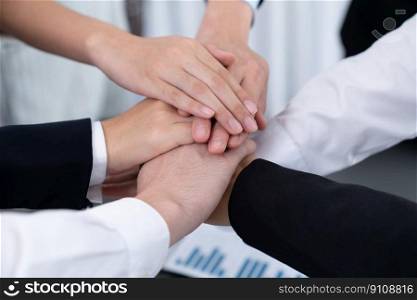 Top view closeup business team of suit-clad businesspeople join hand stack together. Colleague collaborate and work together to promote harmony and teamwork concept in office workplace.. Top view closeup business team join hand stack together for harmony concept.