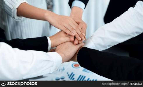 Top view closeup business team of suit-clad businesspeople join hand stack together. Colleague collaborate and work together to promote harmony and teamwork concept in office workplace.. Top view closeup business team join hand stack together for harmony concept.