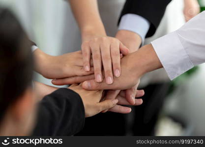 Top view closeup business team of suit-clad businesspeople join hand stack together. Colleague collaborate and work together to promote harmony and teamwork concept in office workplace.. Top view closeup business team join hand stack together for harmony concept.