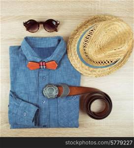 Top view collection of summer male clothing on the wooden background. summer male clothing