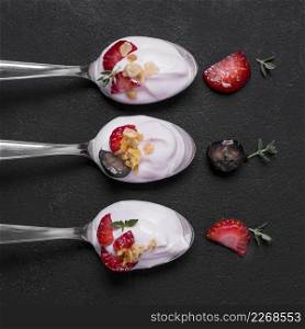 top view collection spoons with yogurt fruits