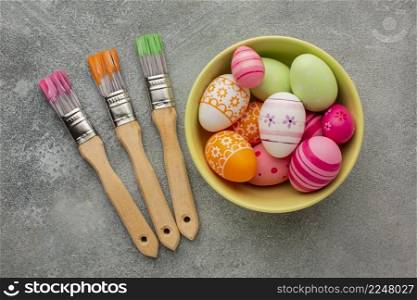 top view colorful easter eggs bowl with paint brushes