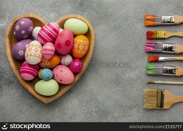 top view colorful easter eggs heart shaped plate with assortment paint brushes